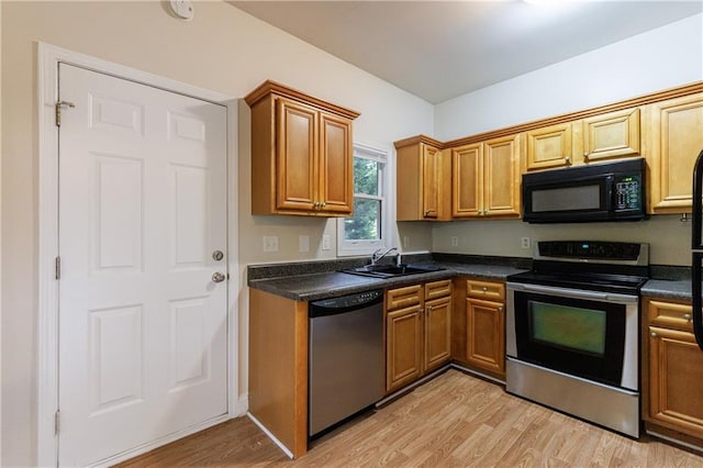 3135 Washington Rd, Atlanta, GA 30344 - kitchen with appliances with stainless steel finishes, a sink, dark countertops, and light wood finished floors