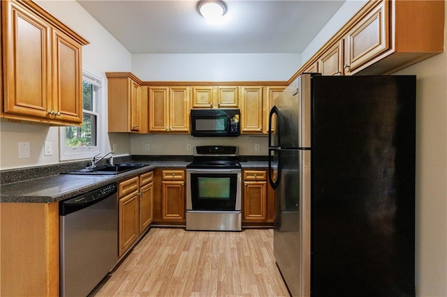 3135 Washington Rd, Atlanta, GA 30344 - kitchen with stainless steel appliances, a sink, light wood finished floors, dark countertops, and brown cabinetry