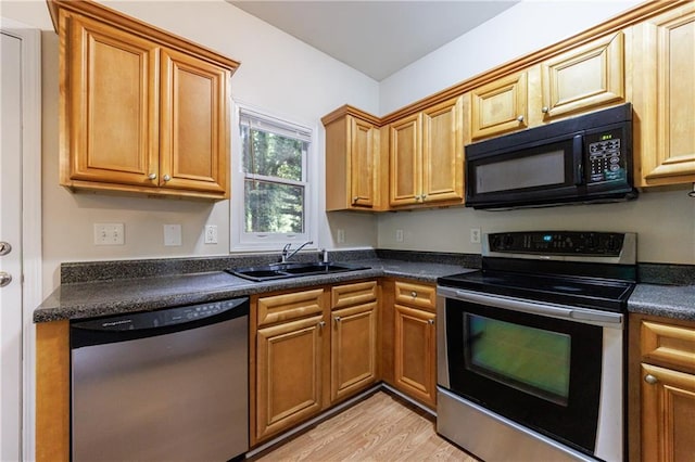 3135 Washington Rd, Atlanta, GA 30344 - kitchen with stainless steel appliances, a sink, dark countertops, light wood-type flooring, and brown cabinetry