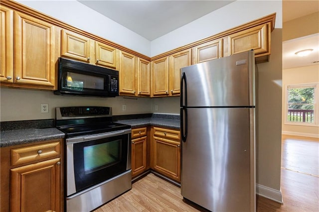 3135 Washington Rd, Atlanta, GA 30344 - kitchen featuring appliances with stainless steel finishes, dark countertops, light wood-type flooring, and brown cabinets