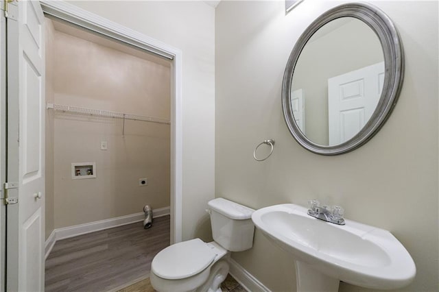 3135 Washington Rd, Atlanta, GA 30344 - bathroom with wood finished floors, a sink, toilet, and baseboards