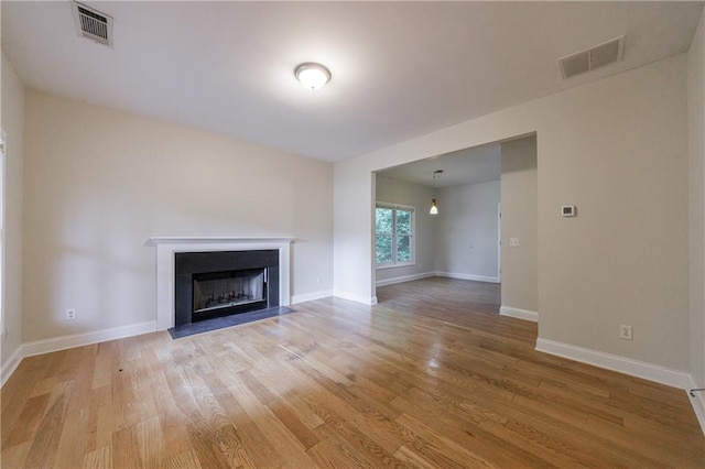 3135 Washington Rd, Atlanta, GA 30344 - unfurnished living room with light wood-style flooring, a fireplace with flush hearth, and baseboards