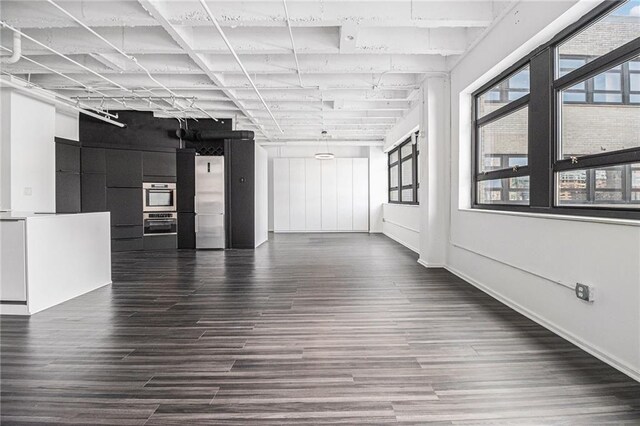 empty room with dark wood finished floors and baseboards
