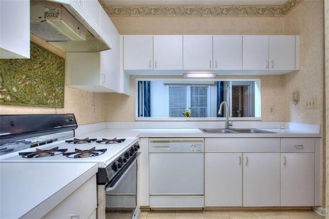 kitchen featuring gas range, white dishwasher, light countertops, under cabinet range hood, and a sink