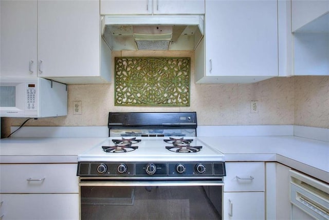 kitchen with white cabinets, black stove, and tasteful backsplash