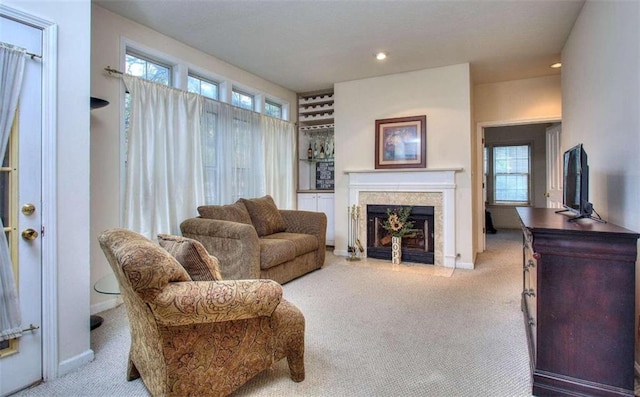 carpeted living area featuring a fireplace, baseboards, a wealth of natural light, and recessed lighting