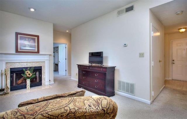 bedroom featuring light carpet, a premium fireplace, and visible vents