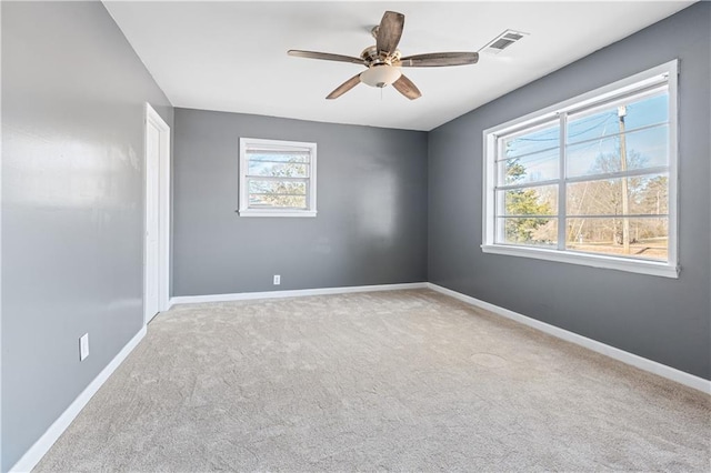 carpeted empty room with plenty of natural light and ceiling fan