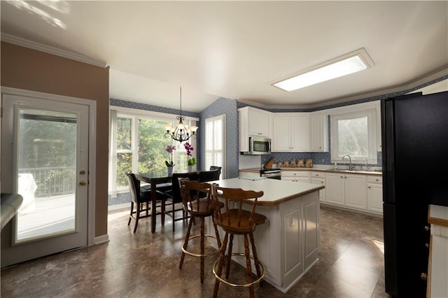 3071 Intrepid Wake, Marietta, GA 30062 - kitchen featuring freestanding refrigerator, stainless steel microwave, white cabinetry, a kitchen breakfast bar, and wallpapered walls