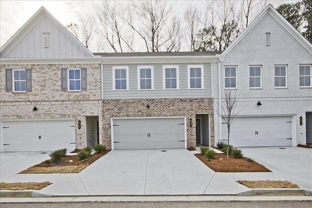 view of property with a garage, brick siding, board and batten siding, and driveway