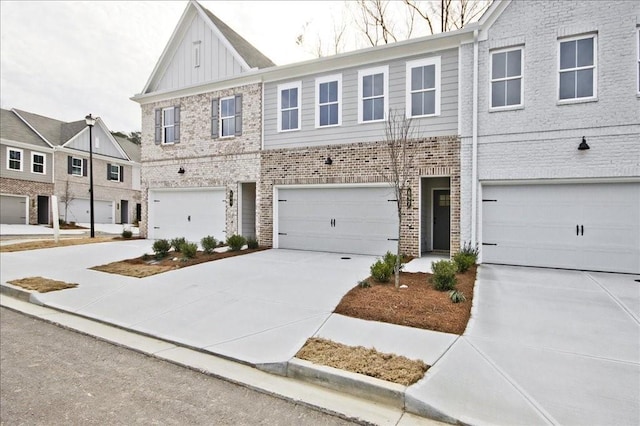 multi unit property featuring brick siding, board and batten siding, concrete driveway, and a garage