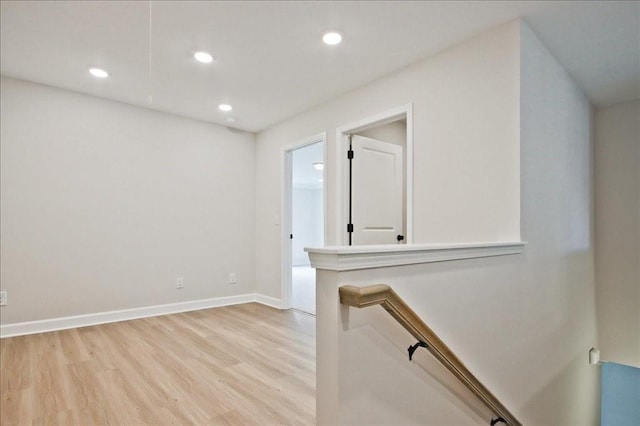 unfurnished room featuring recessed lighting, light wood-type flooring, and baseboards