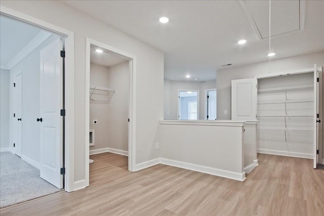 interior space with attic access, baseboards, and light wood-type flooring