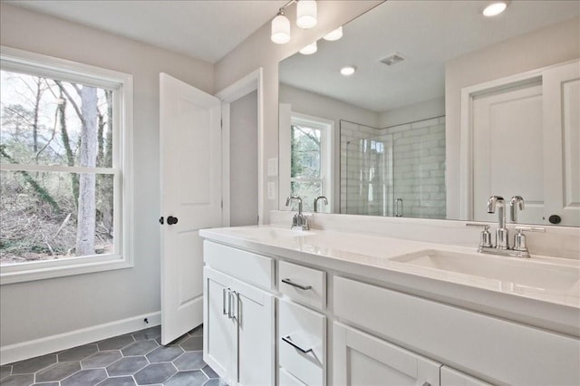 full bathroom with baseboards, visible vents, a stall shower, and a sink