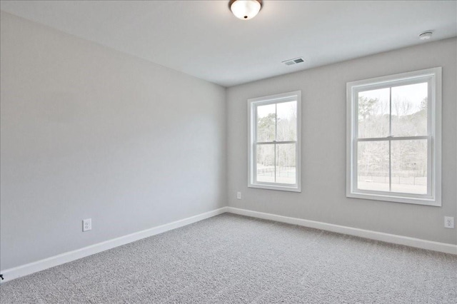 carpeted empty room with visible vents and baseboards