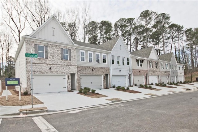 multi unit property with a garage, brick siding, board and batten siding, and driveway