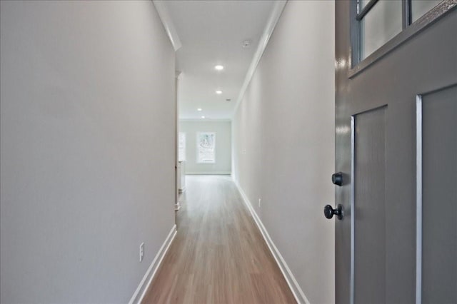 corridor featuring recessed lighting, light wood-style flooring, crown molding, and baseboards