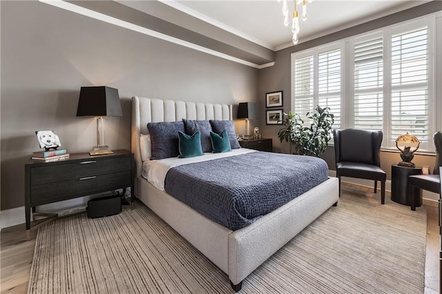 bedroom featuring crown molding, light wood-style flooring, and baseboards