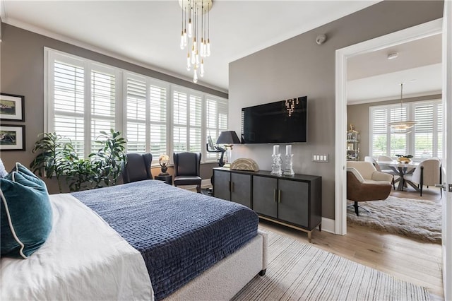 bedroom featuring multiple windows, wood finished floors, ornamental molding, and baseboards
