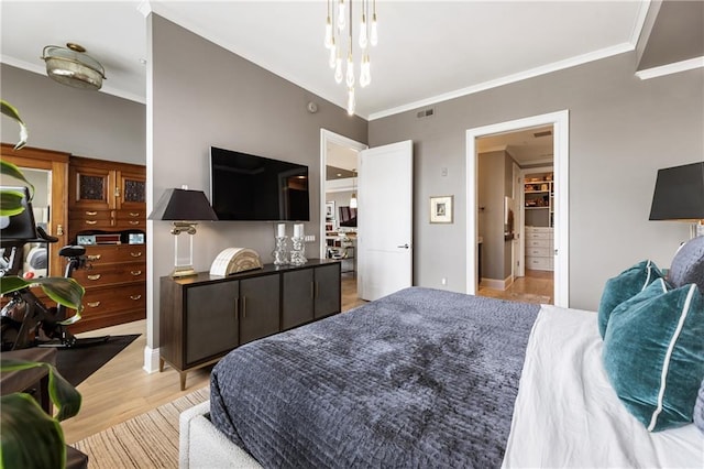 bedroom featuring crown molding and light wood finished floors