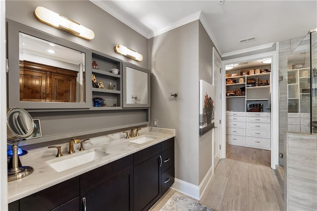 full bathroom with ornamental molding, double vanity, a stall shower, a walk in closet, and built in shelves