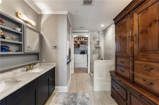 full bathroom with a shower stall, double vanity, wood finished floors, and crown molding