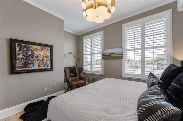 bedroom featuring a chandelier, crown molding, baseboards, and wood finished floors