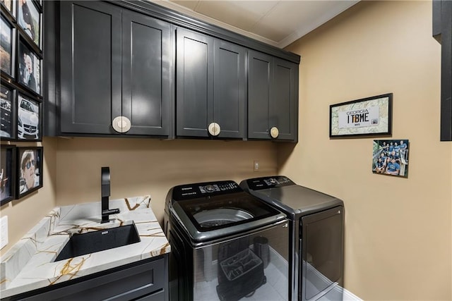 laundry room featuring washer and dryer, cabinet space, and crown molding