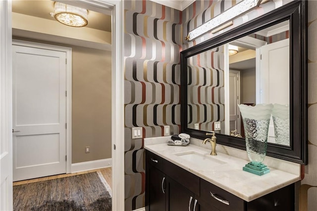 bathroom with baseboards, wood finished floors, and vanity