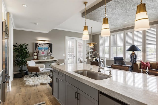 kitchen featuring a sink, crown molding, gray cabinets, light wood-style floors, and plenty of natural light