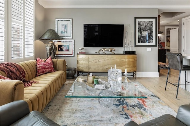 living area featuring ornamental molding, wood finished floors, and baseboards