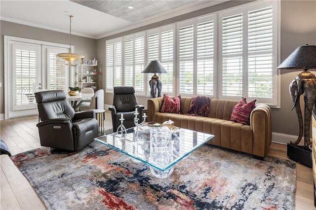 living area featuring wood finished floors, crown molding, and baseboards