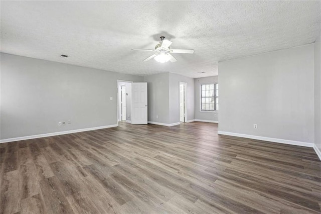 empty room with dark wood-style floors, a textured ceiling, a ceiling fan, and baseboards