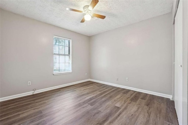 spare room with a ceiling fan, dark wood finished floors, a textured ceiling, and baseboards