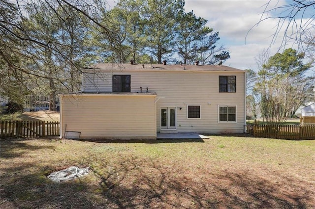 rear view of house featuring a patio area, a fenced backyard, a yard, and french doors