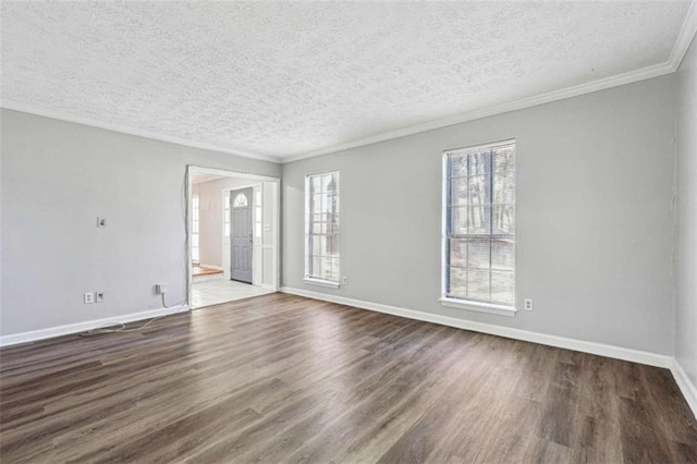 spare room with baseboards, a textured ceiling, dark wood finished floors, and crown molding