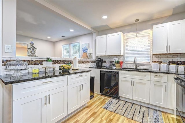 kitchen with dishwasher, white cabinetry, and backsplash