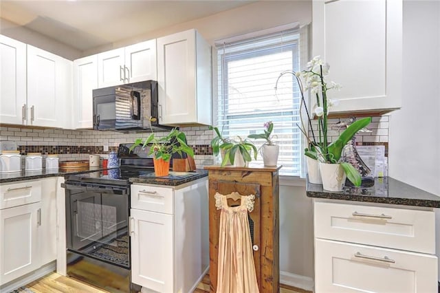 kitchen with black appliances, tasteful backsplash, white cabinetry, and plenty of natural light