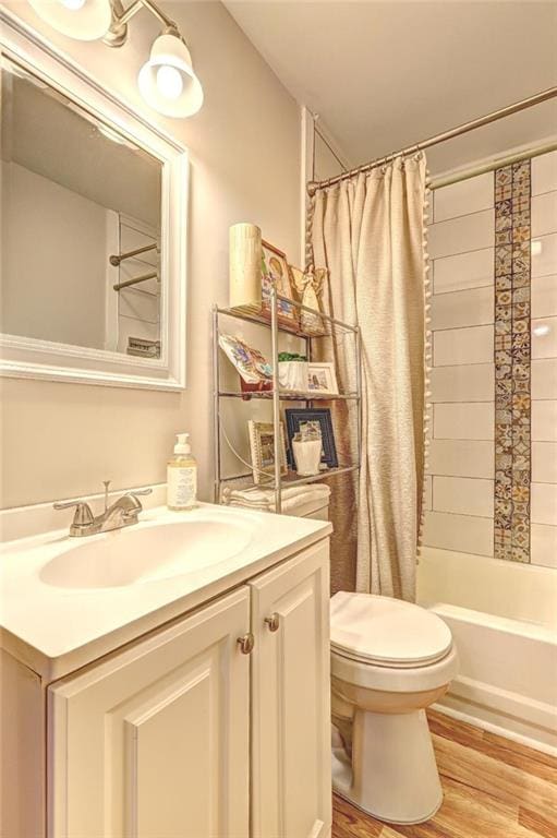 full bathroom with vanity, hardwood / wood-style flooring, toilet, and shower / tub combo with curtain