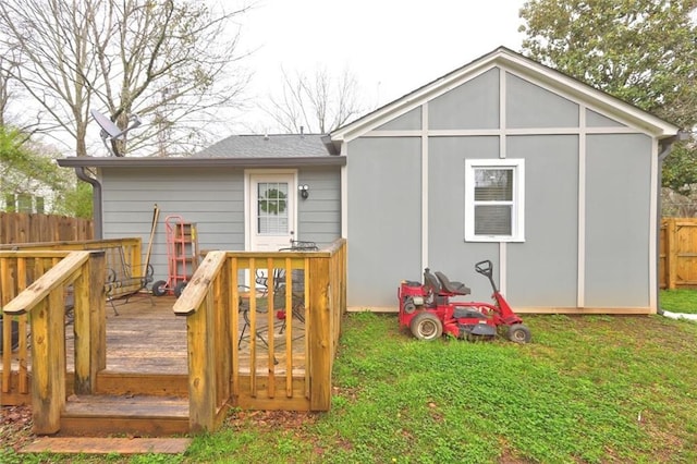 back of property with a deck and a yard