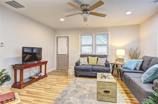 living room with light hardwood / wood-style flooring and ceiling fan