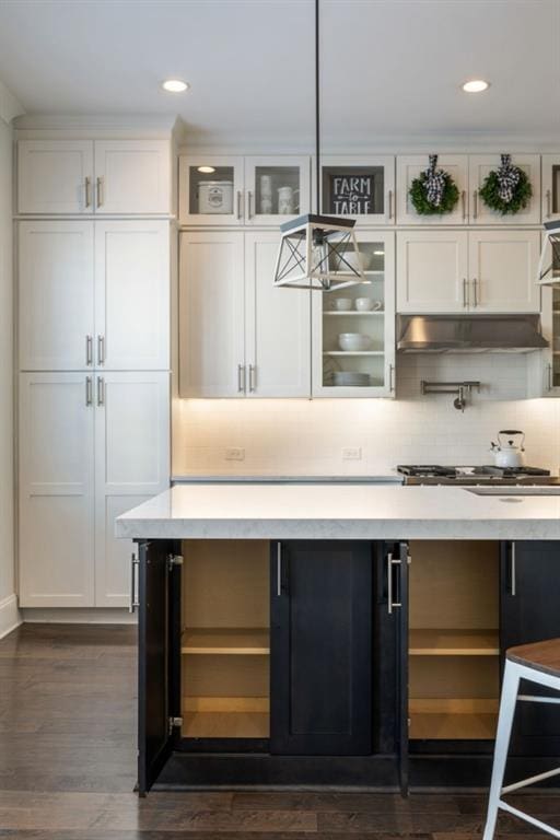 bar with tasteful backsplash, stainless steel gas stovetop, dark hardwood / wood-style floors, and white cabinets