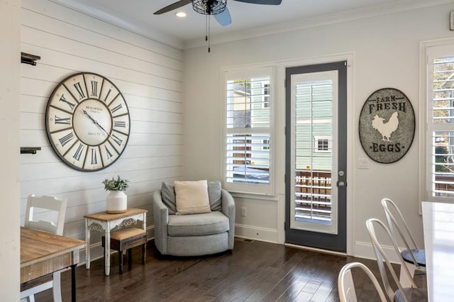 living area with ornamental molding, dark hardwood / wood-style floors, and ceiling fan