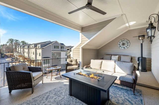 balcony featuring ceiling fan and an outdoor living space with a fire pit