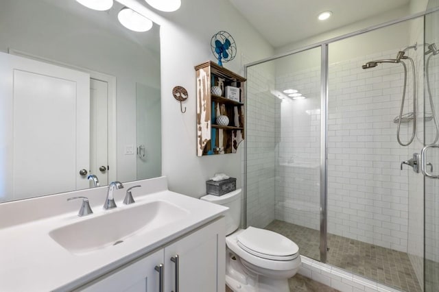 bathroom with vanity, toilet, and a shower with shower door