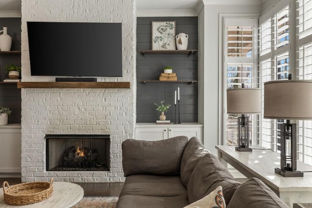 living room with crown molding and a fireplace