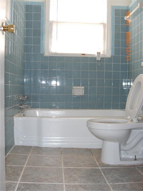 bathroom featuring a wealth of natural light, shower / tub combination, and toilet