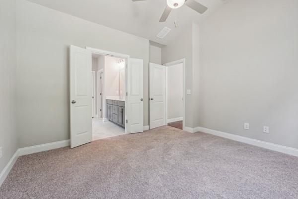 unfurnished bedroom with lofted ceiling, light colored carpet, and ceiling fan