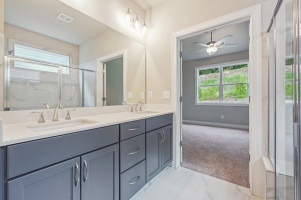 bathroom with vanity and a shower with door