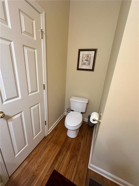 bathroom with toilet and hardwood / wood-style flooring